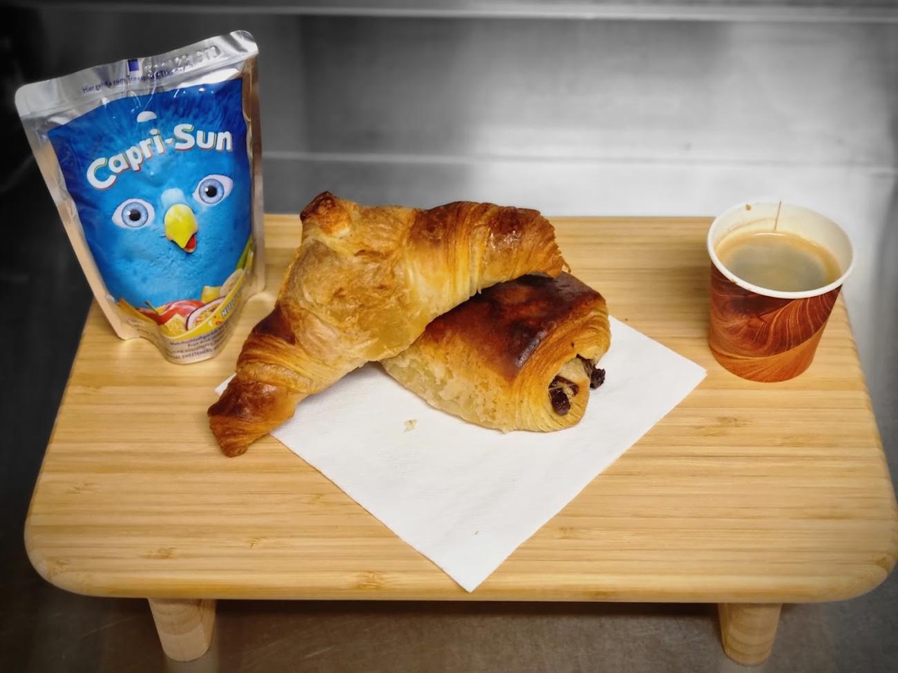 Capri-Sun, croissant, pain au chocolat et café sur un plateau